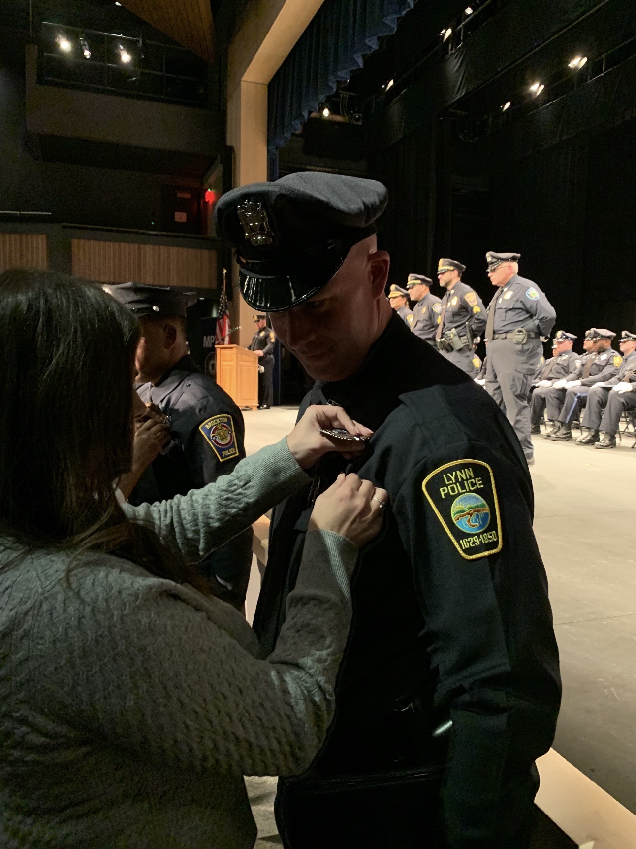 Katrina pinning Michael's badge at his police academy ceremony